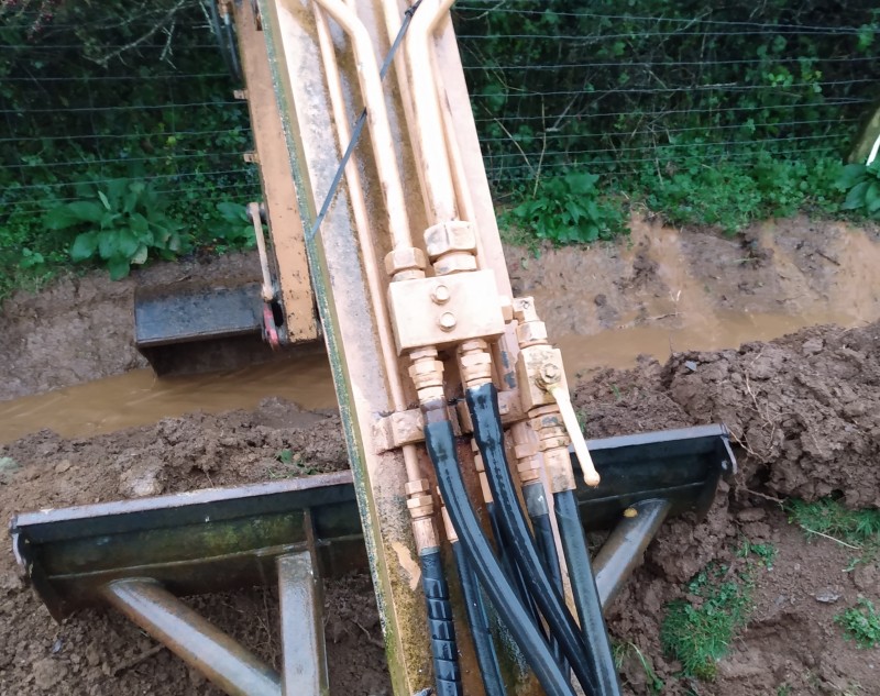 A bit of a panic this morning, the westerly storm we have right now was threatening to wash the new sand school away, so out comes my trusty tracked vehicle to dig drainage as quick as possible to divert the flow of water.